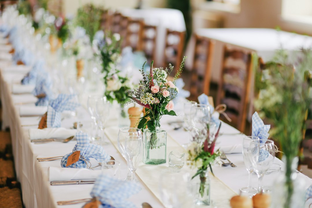 beautifully arranged wedding reception table with floral centerpieces and place settings